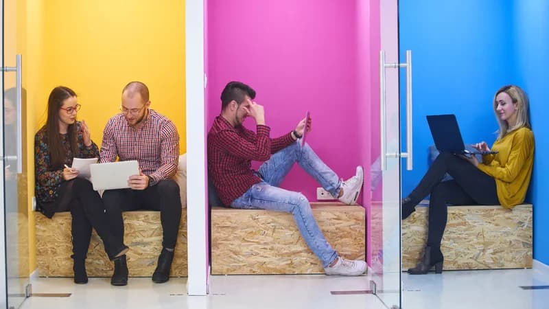 Three work areas with people collaborating, using a tablet and working on a laptop