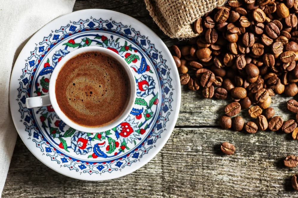Coffee cup beside roasted beans
